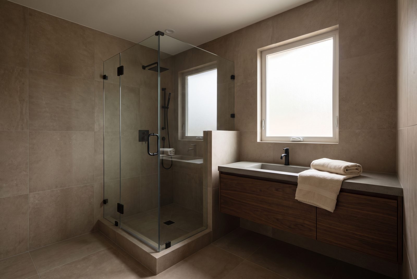 A finished bathroom remodel with large-format tile and a walnut vanity.